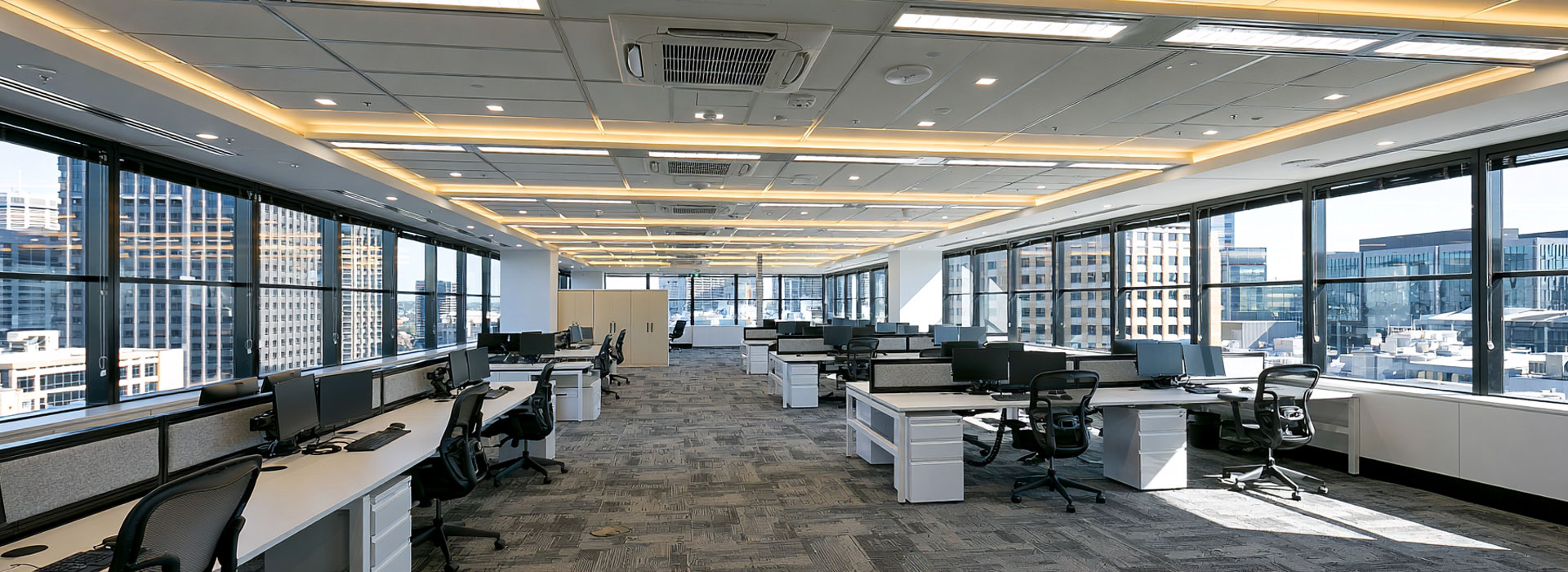 wide photo of a tidy Sydney commercial workspace with portable electrical equipment recently tested and tagged, visible safety tags on extension leads and appliances, organised cables, compliant-looking powerboards, clean professional environment