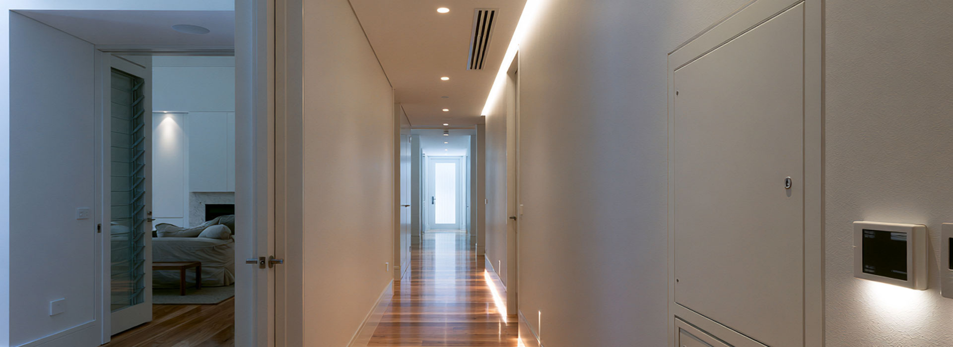 discreet closed electrical switchboard, realistic architectural photograph of a contemporary Sydney home interior, hallway with a discreet closed electrical switchboard cabinet neatly integrated into the wall