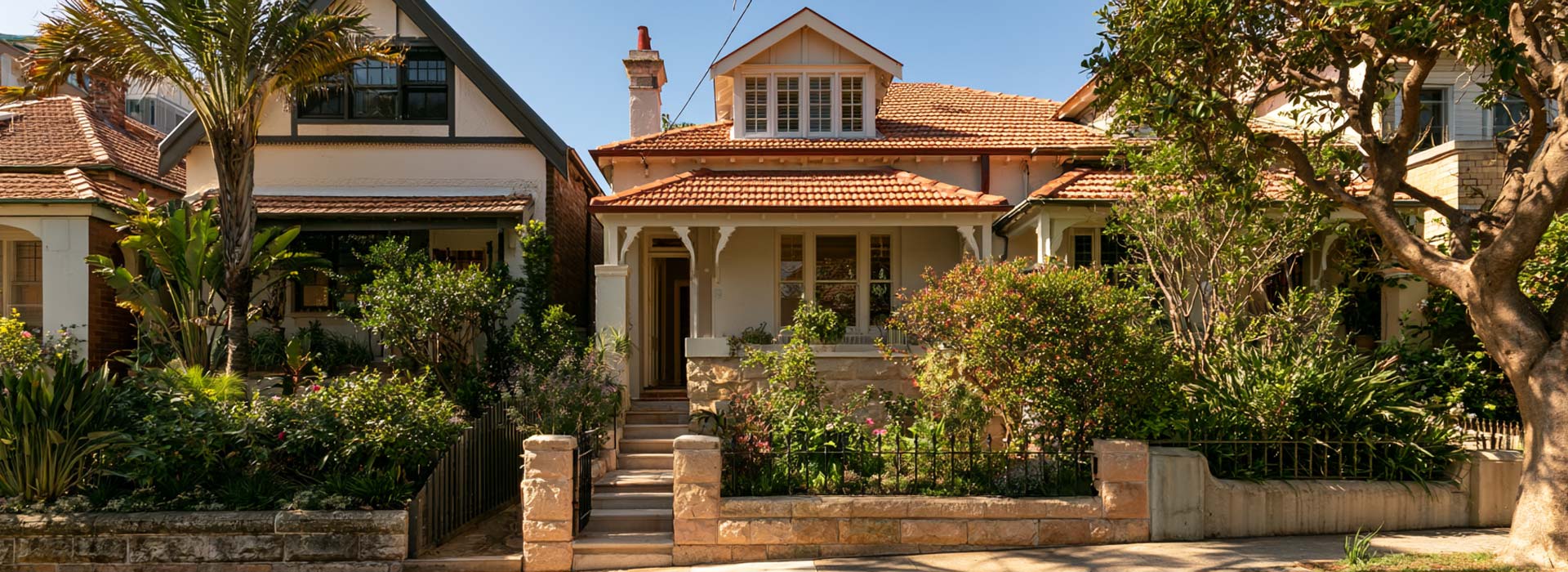 wide architectural photograph of a renovated Federation semi-detached home in Bondi Sydney, sandstone base, red tiled roof, original verandah details, compact leafy residential street, authentic Sydney Eastern Suburbs architecture, natural daylight